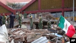 Tentara Meksiko memindahkan puing-puing dari sebuah bangunan kota yang sebagian ambruk yakibat hantaman gempa besar di Juchitan, negara bagian Oaxaca, Meksiko, Jumat, 8 September 2017. (AP Photo / Luis Alberto Cruz)