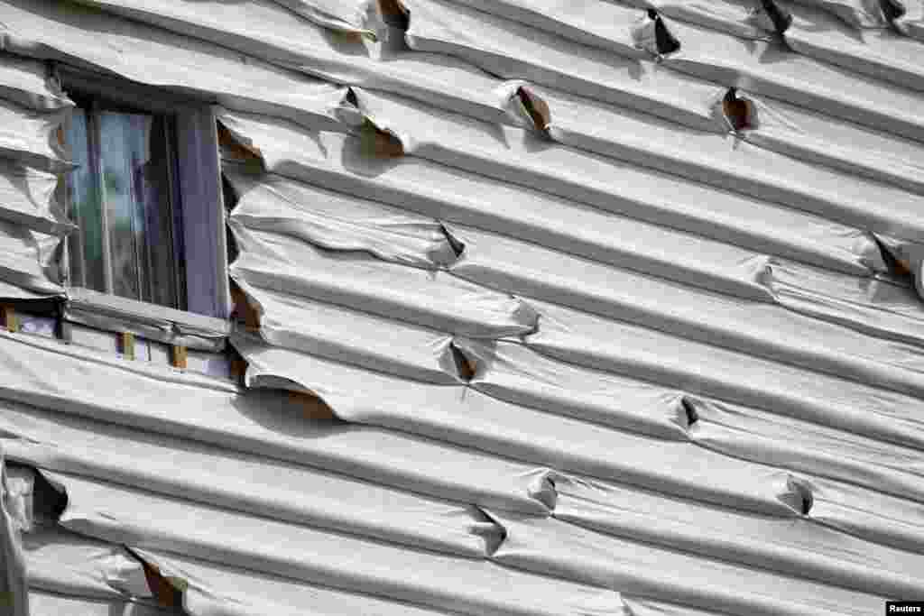 Melted siding on a home is seen near the scene of a train derailment in Lac-Megantic, Quebec. A driverless freight train carrying tankers of petroleum products derailed at high speed and exploded into a giant fireball in the middle of the small Canadian town of Lac-Megantic on July 6, destroying dozens of buildings and leaving an unknown number of people feared missing.