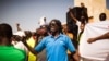 FILE - A man shouts as he and others are seen gathered at the Place de Nation calling for a civilian democratic transition in Ouagadougou, Burkina Faso, Nov. 2, 2014.