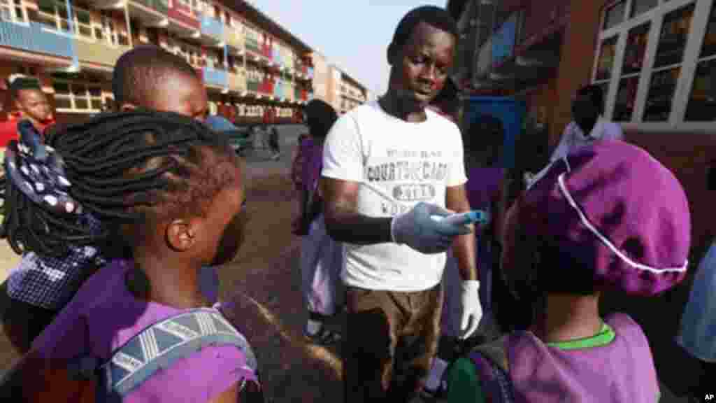 Wani Malami na amfani da na’urar auna zafin jiki domin neman alamun cutar Ebola.