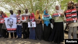 Journalists carry signs demanding freedom of press and expression during a demonstration against the violations of the security services towards the press and journalists outside the Council of the Press and Publication, in Khartoum, Sudan, May 16, 2012.
