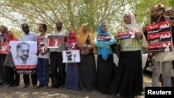 Journalists carry signs demanding freedom of press and expression during a demonstration against the violations of the security services towards the press and journalists outside the Council of the Press and Publication, in Khartoum, Sudan, May 16, 2012.