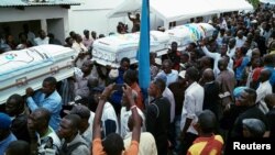 Mourners carry coffins containing the bodies of protesters killed in September rallies organized by the Union for Democracy and Social Progress (UDPS), during a funeral service at UDPS headquarters in Limete, Kinshasa, DRC, Nov. 1, 2016.
