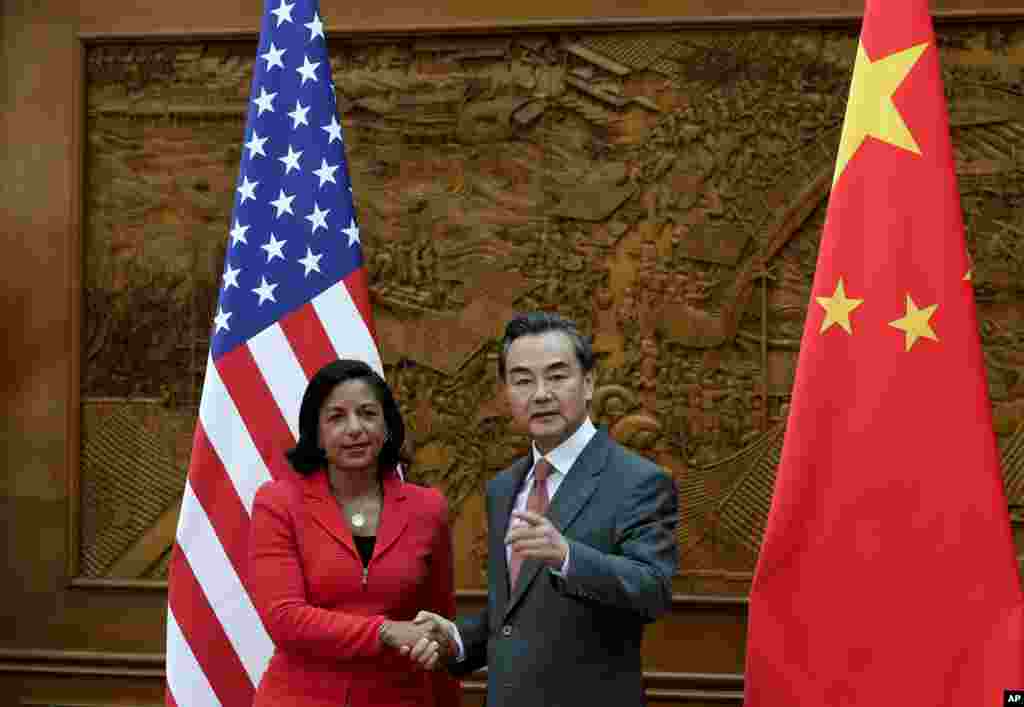 Penasihat Keamanan Nasional AS, Susan Rice, berjabat tangan dengan Menteri Luar Negeri Wang Yi sebelum pertemuan di kantor Kementerian Luar Negeri China di Beijing (9/9). (AP/Andy Wong)