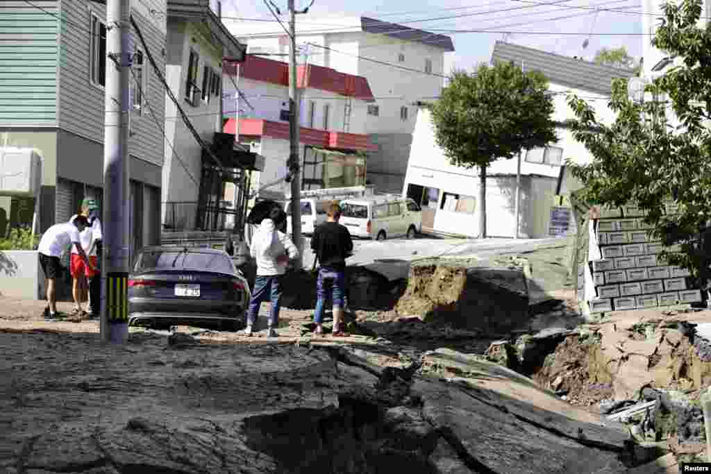 People look at an area damaged by an earthquake in Sapporo on Japan's northern island of Hokkaido, in this photo taken by Kyodo. 