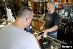 미국의 총기 판매점에서 판매자가 고객에게 총을 보여주고 있다. (자료사진)