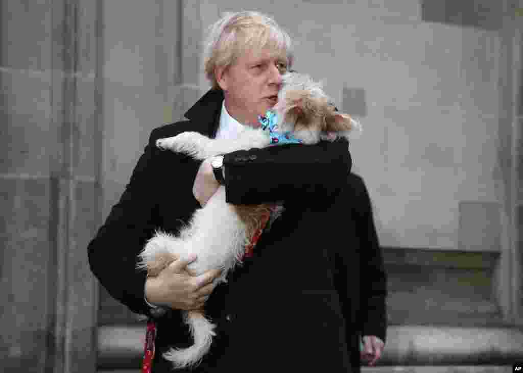 Britain&#39;s Prime Minister and Conservative Party leader Boris Johnson holds his dog Dilyn as he leaves after voting in the general election at Methodist Central Hall, Westminster, London.