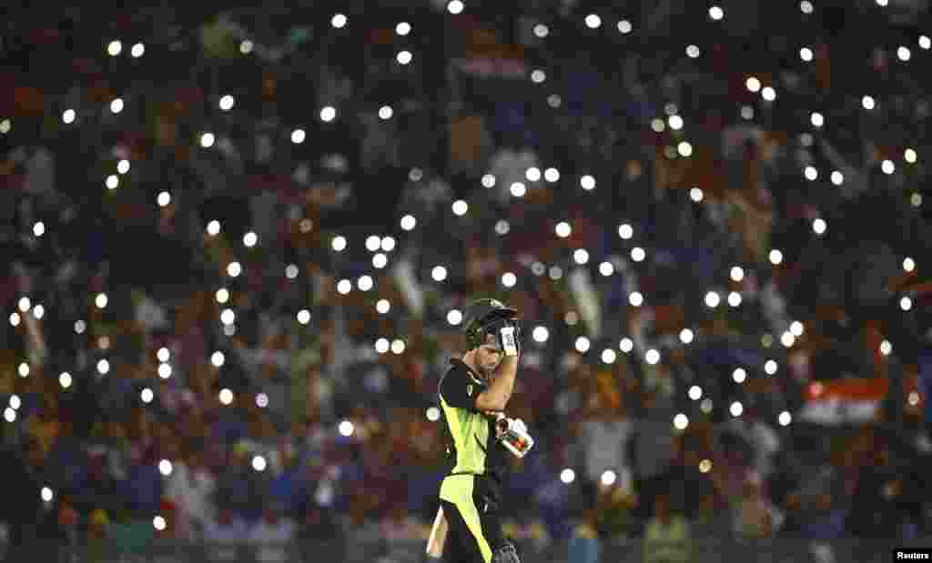 កីឡាករ Glenn Maxwell របស់អូស្រ្តាលីដោះមួកការពាររបស់គាត់ ដើម្បីញ៉ាំទឹក ក្នុងពេលប្រកួត World Twenty20 រវាងប្រទេសឥណ្ឌា និងអូស្រា្តលី នៅក្នុងក្រុង Mohali ប្រទេសឥណ្ឌា។
