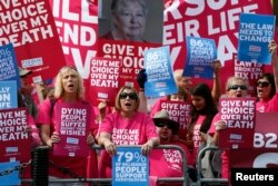 FILE - Campaigners in support of assisted dying protest outside the Houses of Parliament in central London, Sept. 11, 2015. The House of Commons rejected an assisted-dying bill that year, and the practice remains illegal today in Britain.