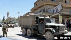 A convoy of Lebanese army soldiers drives at the entrance of the border town of Arsal, in eastern Bekaa Valley, Lebanon, June 30, 2017.