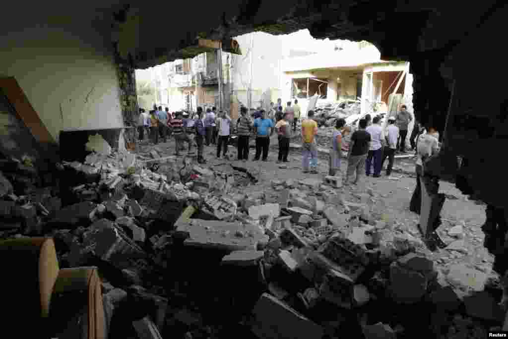 Residents gather at the site of a bomb attack in Kirkuk, Iraq, June 13, 2012.