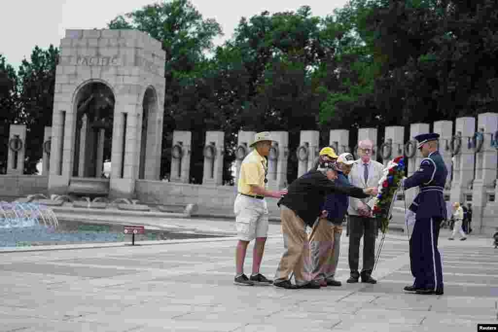 제2차 세계대전 참전용사인 버나드 프리즈랜드씨가 워싱턴 DC의 제2차 세계 대전 기념비에서 열린&nbsp; 메모리얼 데이 기념식에서 화한을 쓰다듬고 있다. 제2차 세계 대전 기념비는 대전 때 사망한 42여 만 명의 미국인들을 기리기 위해 건조된 국립 기념물이다.