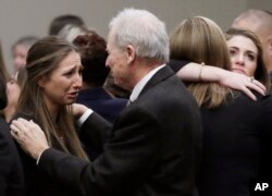Michigan State University Department of Police and Public Safety Chief and Director Jim Dunlap, right, comforts Kyle Stephens, an abuse victim, after a sentencing hearing for Larry Nassar, Jan. 24, 2018, in Lansing, Michigan.