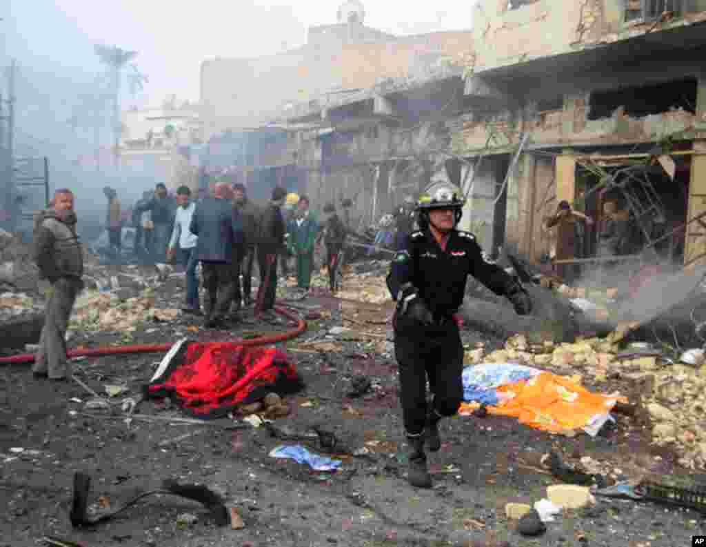Iraqi civil defence personnel and people gather at the site of a bomb attack in Baghdad's northwestern Kadhimiya district on January 5, 2012. (Reuters)