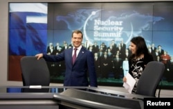 FILE - Russia's President Dmitry Medvedev (L) visits the telecomplex of Russia Today TV channel in Washington.
