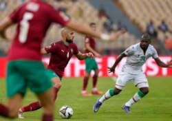 Mchezaji wa Morocco Sofyan Amrabat, kushoto, akimzuia mchezaji wa Comoros El Fardou Ben Nabouhane.