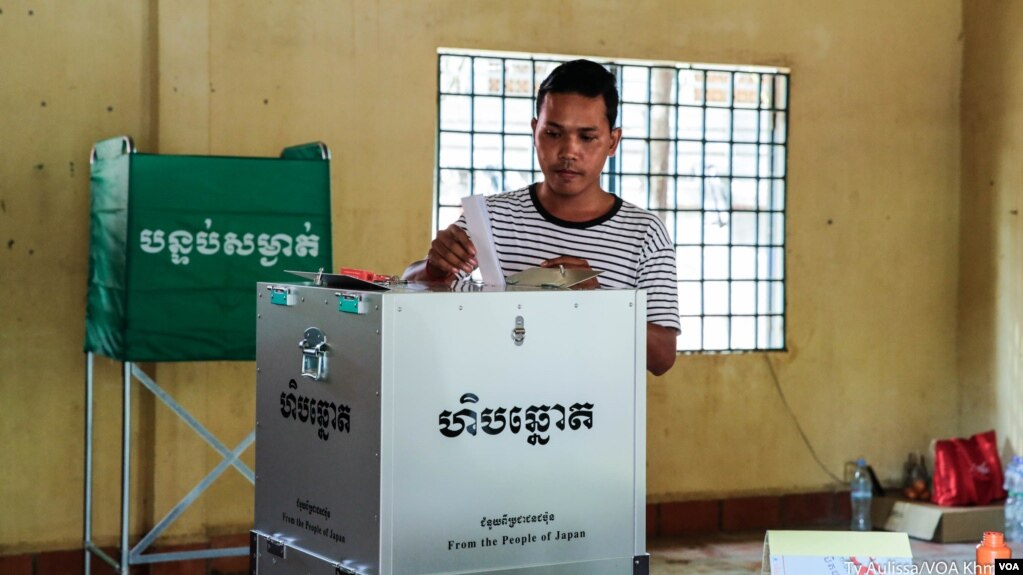បុរស​ម្នាក់​ទម្លាក់​សន្លឹក​ឆ្នោត​របស់​លោក​ទៅ​ក្នុង​ហិប​ឆ្នោត ក្នុង​ការិយាល័យ​បោះ​ឆ្នោត​មួយ នៅ​ខណ្ឌ​សែន​សុខ រាជធានី​ភ្នំពេញ កាលពី​ថ្ងៃ​ទី២៩ ខែ​កក្កដា ឆ្នាំ​២០១៨។ (ទី អូលីស្សា/VOA)