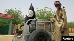 FILE - Fighters from the Islamic militant group the Movement for Unity and Jihad in West Africa ride on a truck in the northeastern Malian city of Gao September 7, 2012.