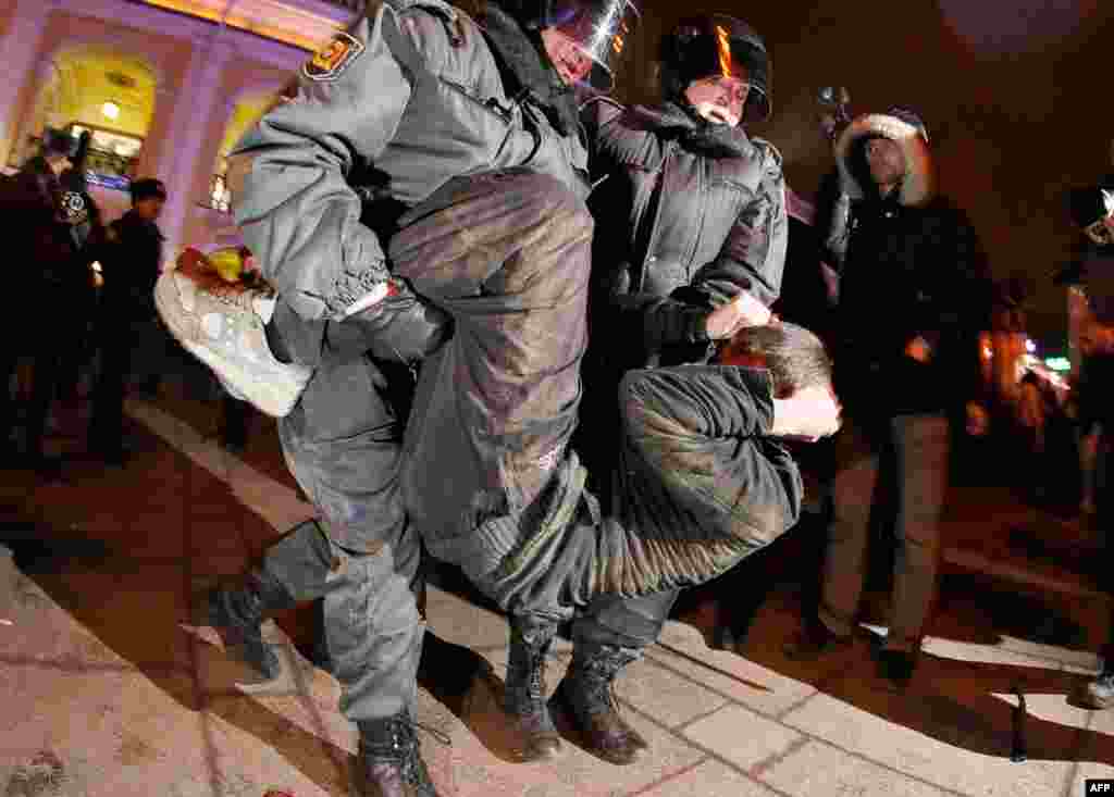 Ngày 7 tháng 12: Cảnh sát chống bạo loạn bắt giữ một người biểu tình trong một cuộc tụ tập tại trung tâm St. Petersburg. (AP/Dmitry Lovetsky)