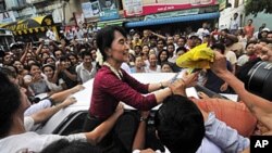 ညောင်ဦးမြို့သို့ ရောက်ရှိလာသည့် မြန်မာ့ဒီမိုကရေစီ ခေါင်းဆောင် ဒေါ်အောင်ဆန်းစုကြည်အား ညောင်ဦး ဒေသခံများက ဝိုင်းဝန်းနှုတ်ဆက်နေကြစဉ်။ ဇူလိုင် ၇၊ ၂၀၁၁။