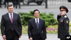 Ukrainian President Viktor Yanukovich (l) and Chinese President Hu Jintao review the honor guard in Kyiv, June 20, 2011