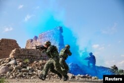 FILE - Soldiers of the Chinese People's Liberation Army (PLA) take part in a combat training in the Gobi desert in Jiuquan, Gansu province, China, May 18, 2018.