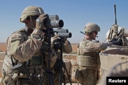 FILE - U.S. soldiers surveil the area during a combined joint patrol in Manbij, Syria, Nov. 1, 2018.