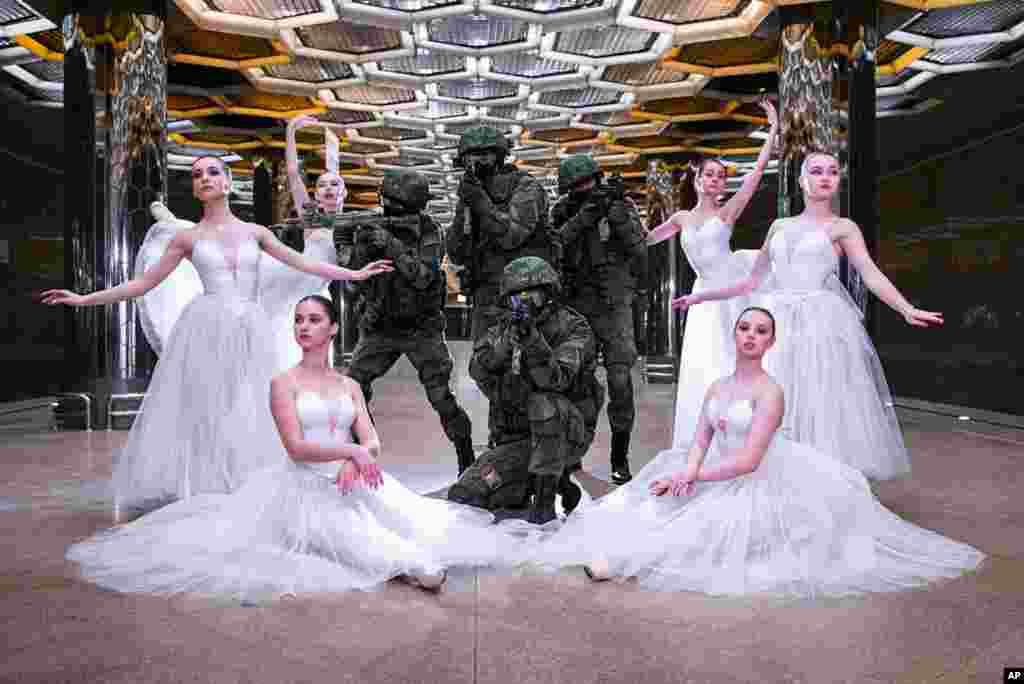 세계 여성의 날 이벤트의 일환으로 무용수들과 군인이 함께 포즈를 취하고 있다.