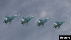FILE - Sukhoi Su-34 Fullback tactical bombers fly in formation over the Red Square during the Victory Day parade in Moscow, Russia, May 9, 2015.