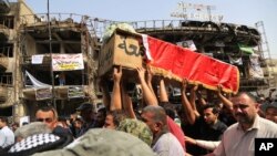 Mourners carry the Iraqi flag-draped coffin of, Akram Hadi, 24, in a Sunday massive truck bomb attack in the Karada neighborhood of Baghdad, Iraq, July 5, 2016. 