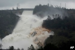 Water flows through break in the wall of the Oroville Dam spillway, in Oroville, Calif., Feb. 9, 2017. The torrent chewed up trees and soil alongside the concrete spillway before rejoining the main channel below.