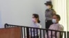 FILE - This handout photo taken May 24, 2021, and released by Myanmar's Ministry of Information May 26, shows detained civilian leader Aung San Suu Kyi (L) and detained president Win Myint (R) during their first court appearance in Naypyidaw. 