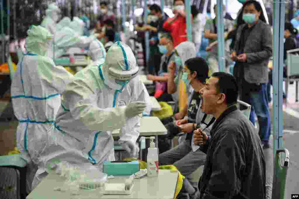 A medical worker takes a swab sample from a resident to be tested for the COVID-19 in Wuhan in China&#39;s central Hubei province.&nbsp;Nervous residents of the pandemic epicenter queued up across the city for testing after a new cluster of cases sparked a mass screening campaign.