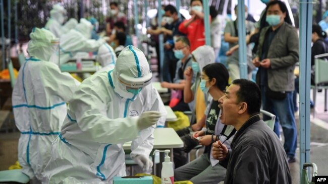 武汉一名医务人员正在对一位市民进行新冠状病毒检测。(2020年5月14日)
