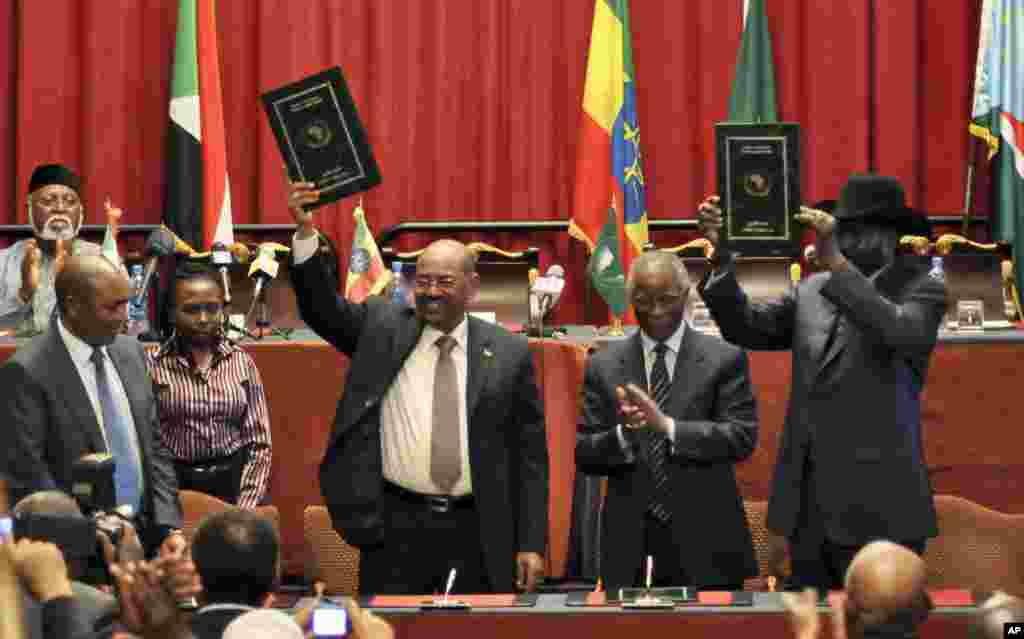 Sudan's President Omar al-Bashir, center-left, and South Sudan President Salva Kiir (r) celebrate the signing of 9 agreements, in Addis Ababa, Ethiopia, September 27, 2012.
