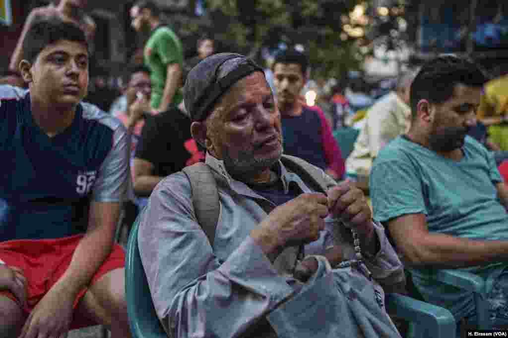 A blind man among the fans watching the match between Egypt and Saudi Arabia listens to the commentator in Shubra, Cairo, Egypt. Fans knew their team, disqualified, would go home after the match but many chose to stay and watch until the end.