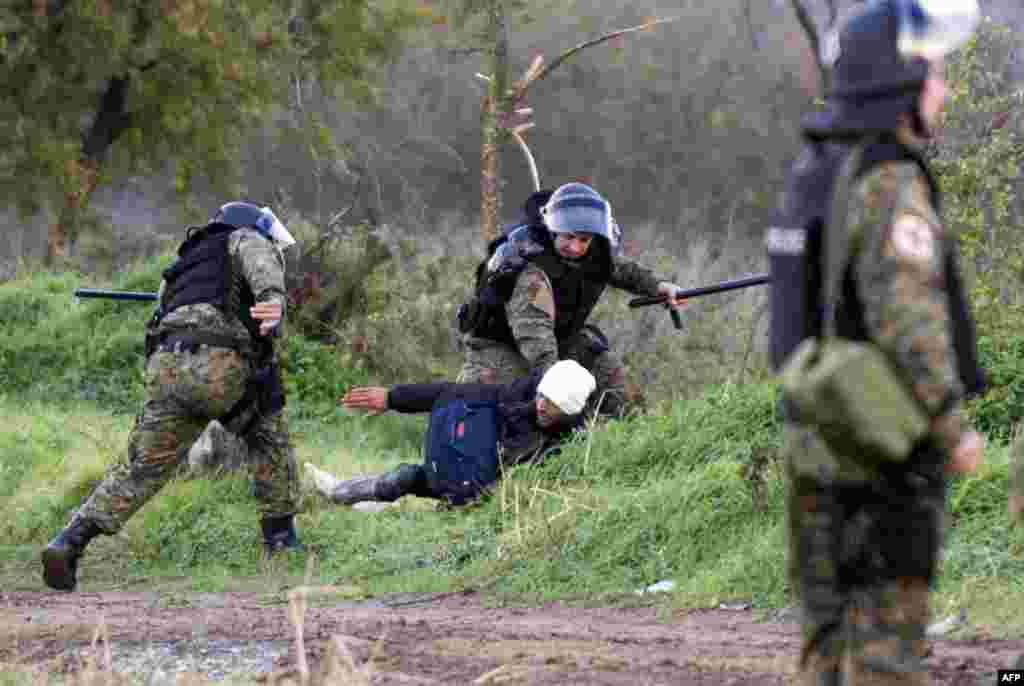 Macedonian policemen (with headgear) hold back a migrant with clashes near Gevgelija at the Greek-Macedonian border. Over 200 migrants tried to break through barbed wire fences to cross from Greece into Macedonia, which imposed new border restrictions last week, throwing stones at police.&nbsp;