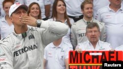 FILE - Racing champion Michael Schumacher acknowledges fans before the Brazilian Formula 1 Grand Prix at Interlagos Circuit in Sao Paulo November 25, 2012.