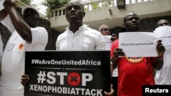 People protesting against xenophobia in South Africa hold placards in front of the South African consulate in Lagos, April 16, 2015. 