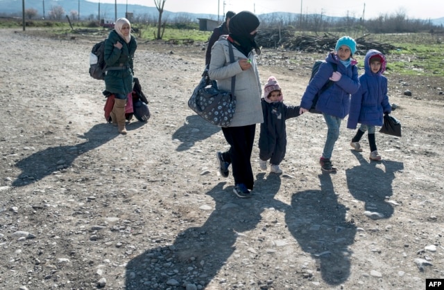 A woman and children cross the Greek-Macedonian border near the town of Gevgelija, Feb. 25, 2016. Merkel has said an EU solution cannot be done in a way that abandons Greece.