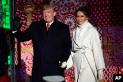 El presidente Donald Trump y la primera dama de Estados Unidos, Melania Trump, saludan al público después de encender el Árbol Nacional de Navidad, cerca de la Casa Blanca. Noviembre 28 de 2018.