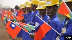 FILE - Students at the vocational training center of reference (Centre de formation professionnelle de reference de Ziniare (CFPR-Z)) in Ziniare, 35kms of Ouagadougou hold Taiwan's and Burkina Faso's flags during the visit of Taiwan's President on April 9