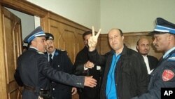 Rachid Nini being escorted into the courtroom in Morocco