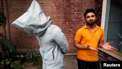 سعود بلوچ، هنرمند ۲۸ ساله پاکستانی در لاهور، در کنار تندیسی که به نام «بی هراس» ساخته است. 