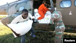 Workers offload food aid from a South African National Defence Force helicopter in the aftermath of Cyclone Idai in Buzi, near Beira, Mozambique, March 25, 2019.