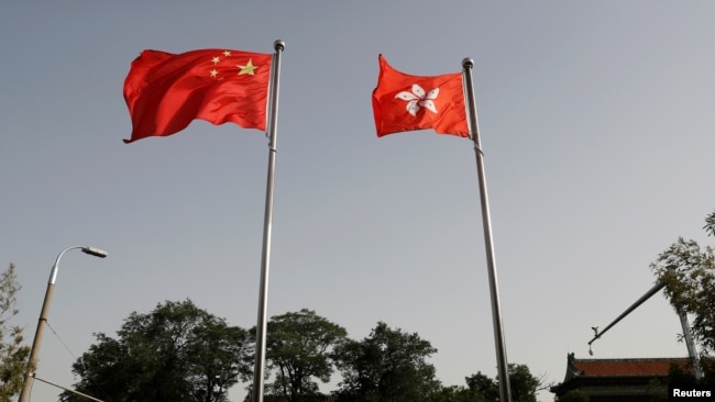 中国和香港的旗帜在特区政府办公楼前飘扬。（2020年6月3日）