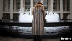 Seorang perempuan mengenakan jaket dari bulu hewan di depan Lincoln Center saat gelaran Pekan Fesyen New York, 12 February 2013.