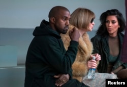 FILE - Singer Kanye West watches models rehearse while sitting with his wife Kim Kardashian (R) and Anna Wintour before presenting his Fall/Winter 2015 partnership with Adidas at New York Fashion Week .