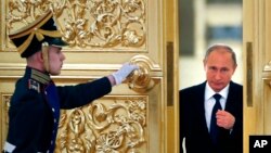 FILE - Russian President Vladimir Putin, right, enters the Alexadrovsky Hall to head a meeting of the Presidential Council for Civil Society and Human Rights at the Kremlin in Moscow, Russia, Thursday, Oct. 1, 2015.