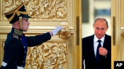 FILE - Russian President Vladimir Putin, right, enters the Alexadrovsky Hall to head a meeting of the Presidential Council for Civil Society and Human Rights at the Kremlin in Moscow, Oct. 2015.